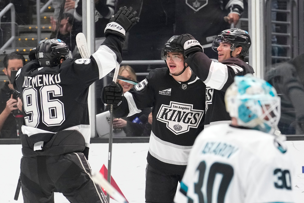 Los Angeles Kings center Alex Turcotte, second from left, cele braces his goal with left wing Andrei Kuzmenko, left, and left wing Kevin Fiala, second from right, as San Jose Sharks goaltender Yaroslav Askarov sits inn goal during the second period of an NHL hockey game Wednesday, Jan. 7, 2026, in Los Angeles. (AP Photo/Mark J. Terrill)