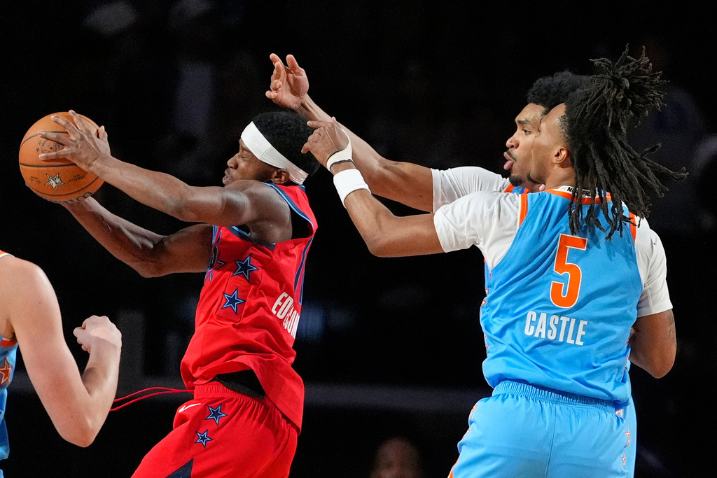 Team Vince guard VJ Edgecombe (77) of the Philadelphia 76ers, left, grabs a rebound as Team Melo guard Dylan Harper (2) of the San Antonio Spurs, center, and guard Stephon Castle (5) of the San Antonio Spurs reach for it during a final in NBA basketball's Rising Stars event Friday, Feb. 13, 2026, in Inglewood, Calif. (AP Photo/Mark J. Terrill)
