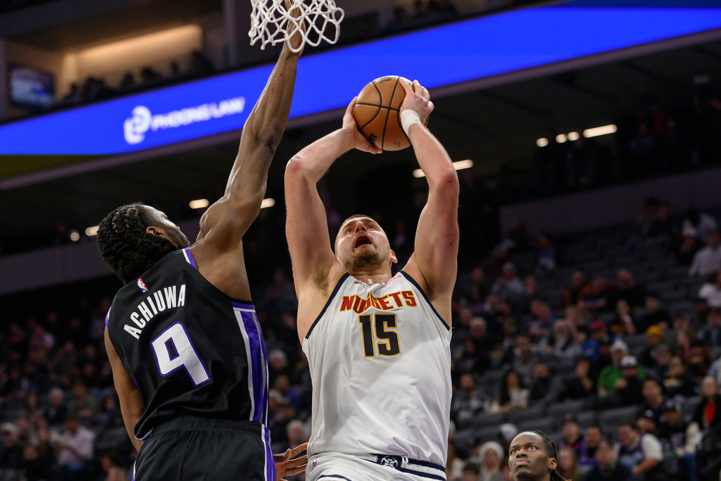 Denver Nuggets center Nikola Jokic (15) shoots over Sacramento Kings forward Precious Achiuwa (9) during the first half of an NBA basketball game in Sacramento, Calif., Thursday, Dec. 11, 2025. (AP Photo/Randall Benton)