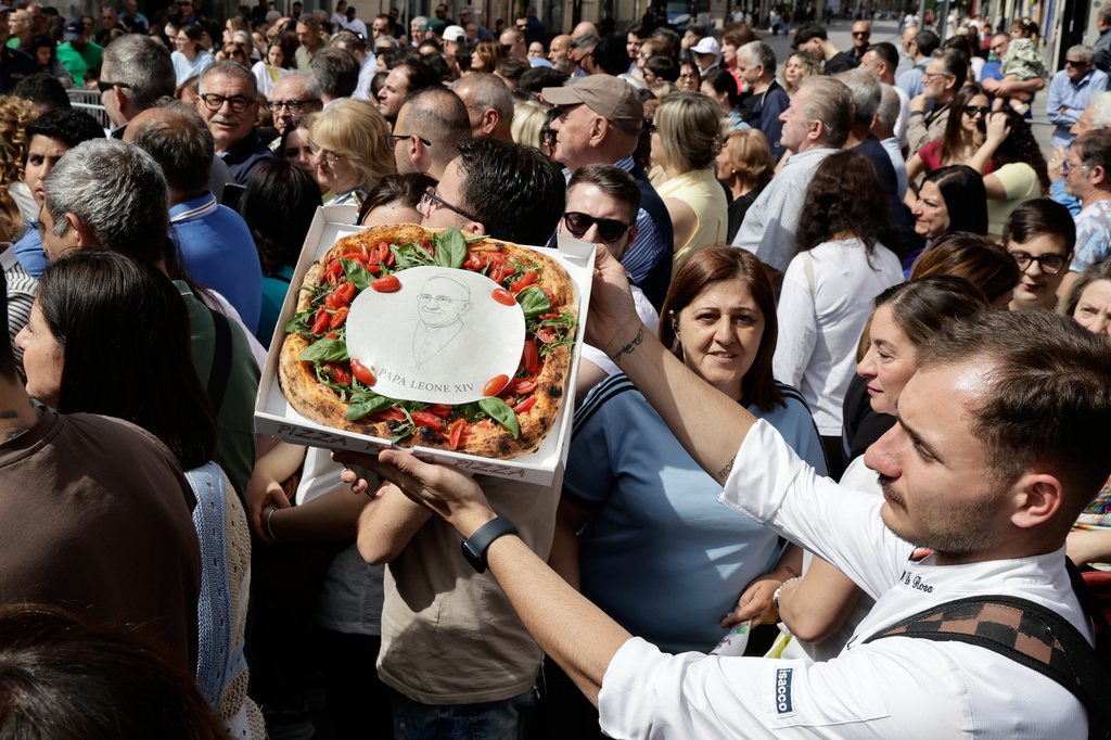 A man presents a pizza with the portrait of Pope Leo XIV during his a one-day pastoral visit in Acerra, Italy, Saturday, May 23, 2026. (AP Photo/Salvatore Laporta)