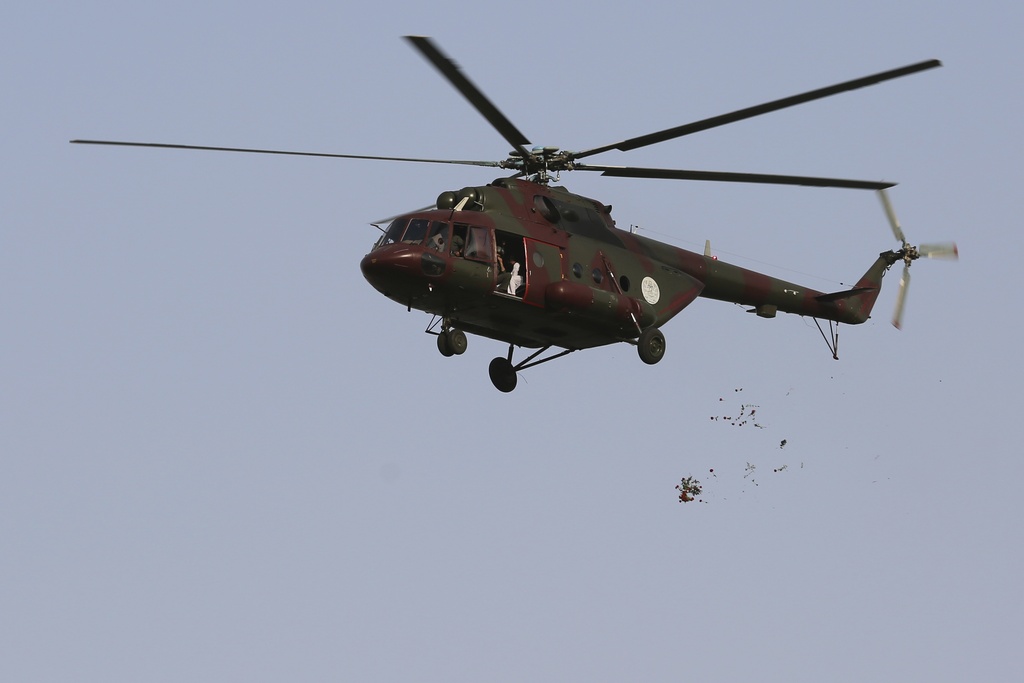 A military helicopter drops flowers over the city during celebrations marking the fourth anniversary of the U.S. withdrawal and the start of Taliban rule in Kabul, Afghanistan, Friday, Aug. 15, 2025. (AP Photo/Siddiqullah Alizai)