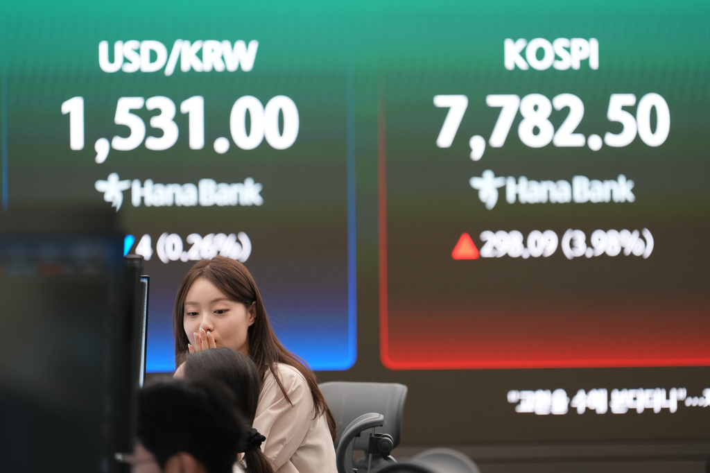 A dealer talks near the screens showing the Korea Composite Stock Price Index (KOSPI) and the foreign exchange rate between U.S. dollar and South Korean won at a dealing room of Hana Bank in Seoul, South Korea, Tuesday, June 9, 2026. (AP Photo/Lee Jin-man)
