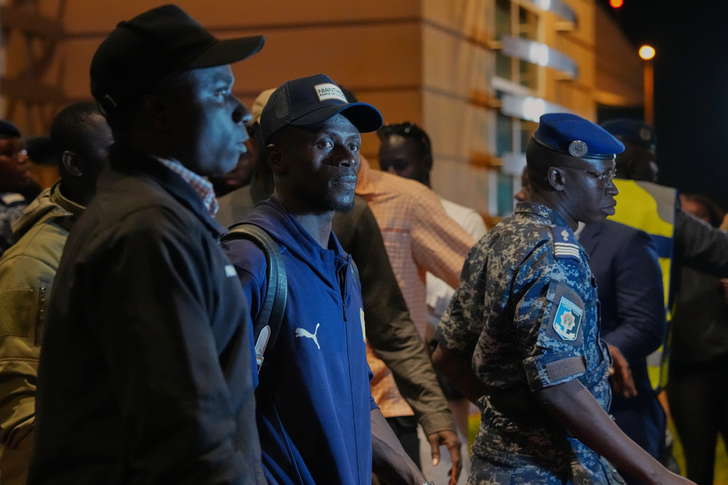 Senegal's Sadio Mane, center, is accompanied by securities as the team arrives following their victory in the Africa Cup of Nations soccer tournament, in Ndiass, Senegal, Tuesday, Jan. 20, 2026. (AP Photo/Misper Apawu)