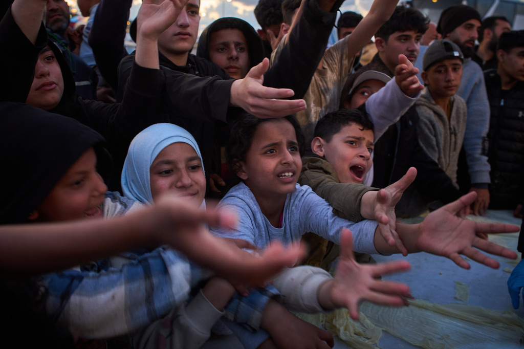 Displaced people wait to receive donated food beside the tents they use as shelters after fleeing Israeli bombardment in southern Lebanon, in Beirut, Lebanon, Monday, April 6, 2026. (AP Photo/Emilio Morenatti)