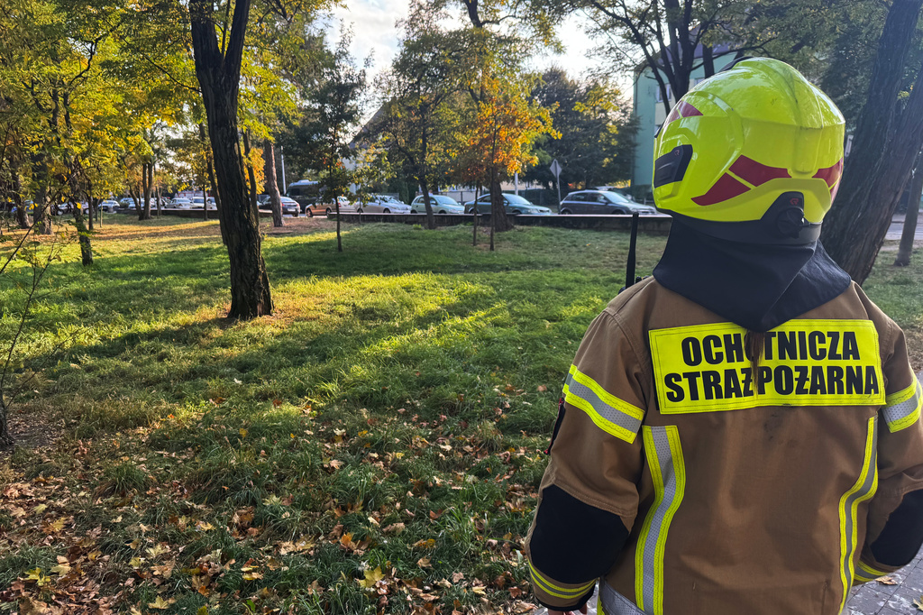 A volunteer firefighter stands near the scene following an attack on the Vocational School Complex No. 4 in Ostroleka, Poland, Wednesday, Oct. 7, 2026. (AP Photo/Rafal Niedzielski)