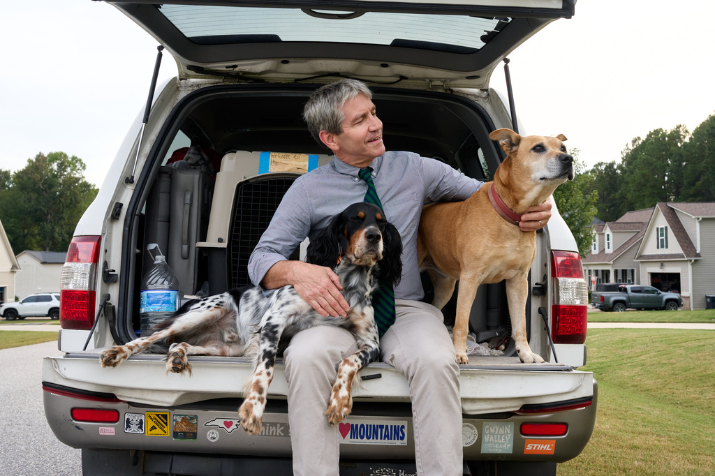 Paul Barringer, the Democratic nominee running for North Carolina's 13th Congressional District, poses for a photo with his dogs, Billie and Penny, on Oct. 8, 2026, in Garner, N.C. (AP Photo/Matt Ramey)