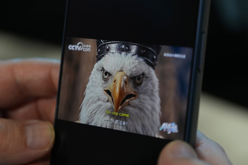 An AI-made viral animation released by Chinese state media mocking the United States as a white eagle is seen on a mobile phone in Beijing, China, Monday, April 6, 2026. (AP Photo/Ng Han Guan)