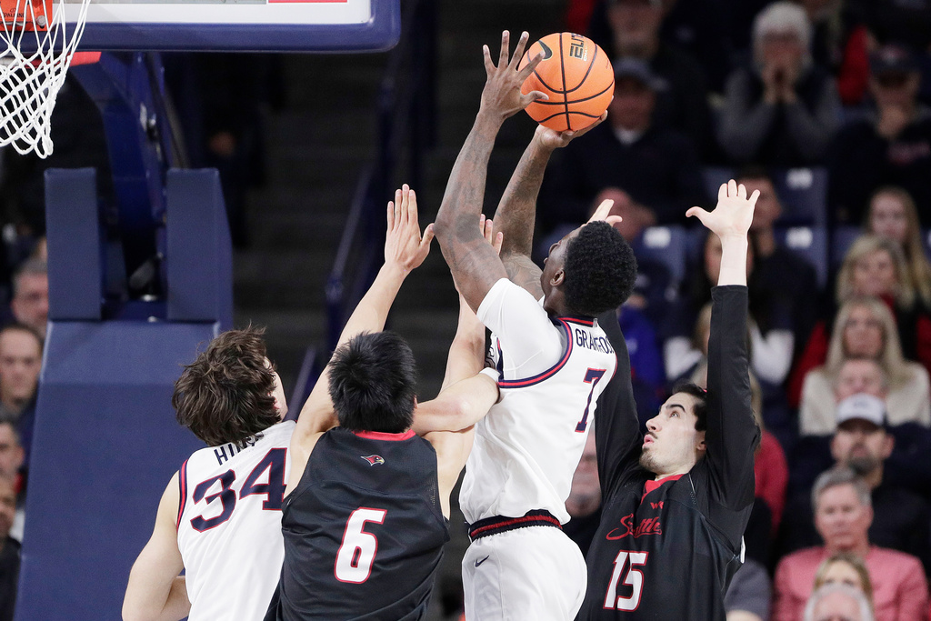 Gonzaga guard Tyon Grant-Foster (7) shoots nexar to teammate Braden Huff (34) and between Seattle center Houran Dan (6) and forward Will Heimbrodt (15) during overtime in an NCAA college basketball game, Friday, Jan. 2, 2026, in Spokane, Wash. (AP Photo/Young Kwak)
