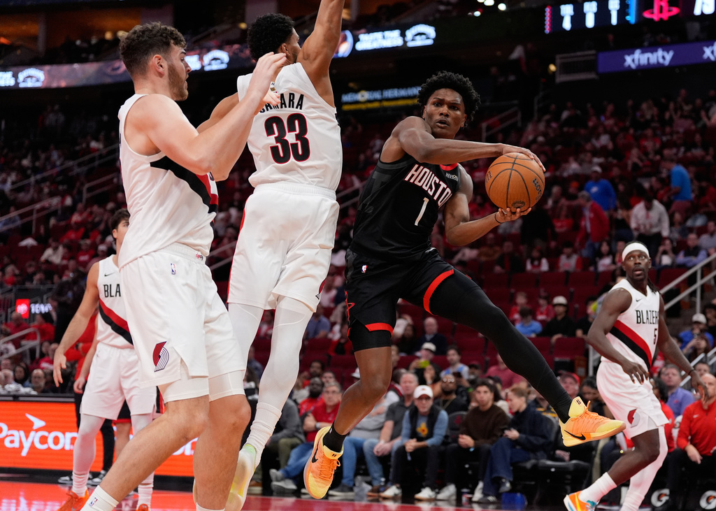 Houston Rockets guard Amen Thompson (1) passes against Portland Trail Blazers forward Toumani Camara (33) during the second half of an NBA Cup basketball game in Houston, Friday, Nov. 14, 2025. (AP Photo/Ashley Landis)