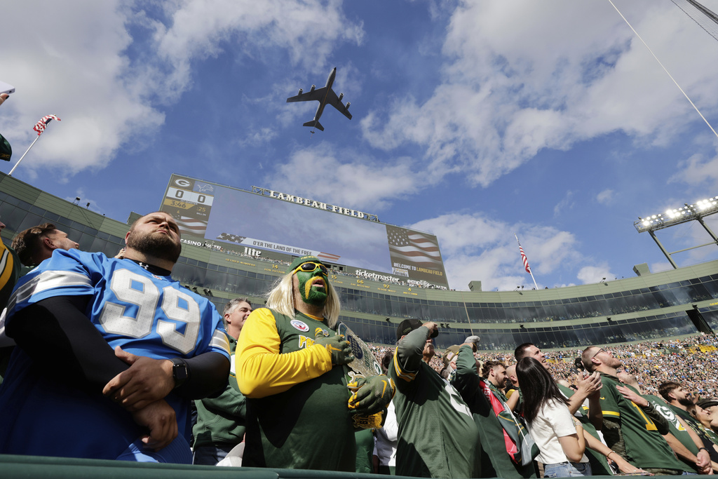 Fans watch during a flyover at Lambeau Field at an NFL football game between the Green Bay Packers and Detroit Lions Sunday, Sept. 7, 2025, in Green Bay, Wis. (AP Photo/Mike Roemer)