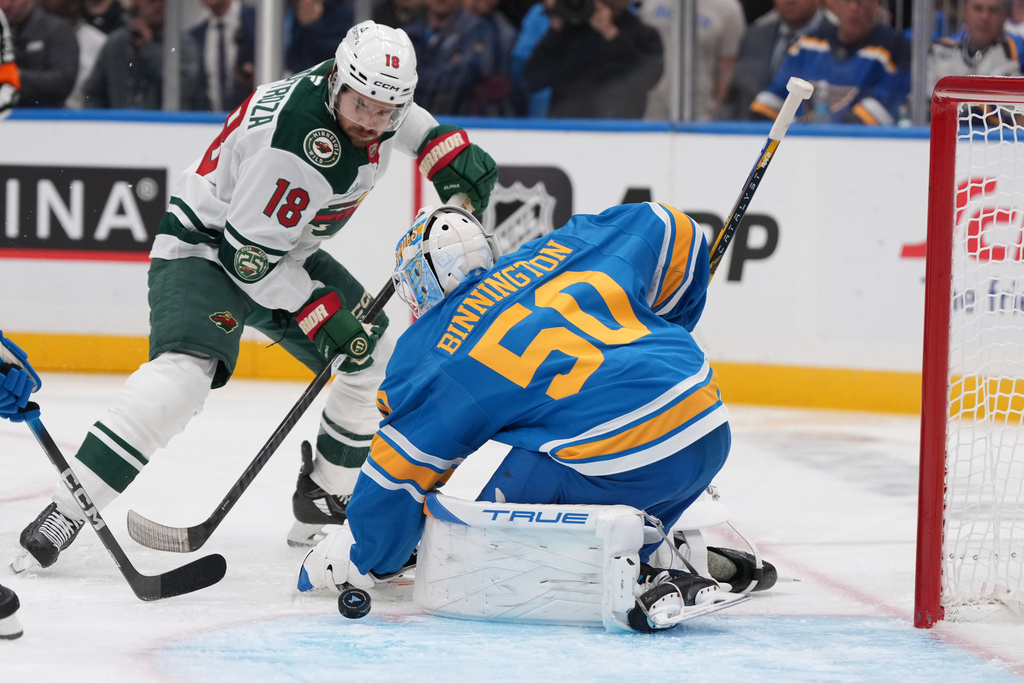Minnesota Wild's Vinnie Hinostroza (18) is unable to score past St. Louis Blues goaltender Jordan Binnington (50) during the first period of an NHL hockey game Thursday, Oct. 9, 2025, in St. Louis. (AP Photo/Jeff Roberson)