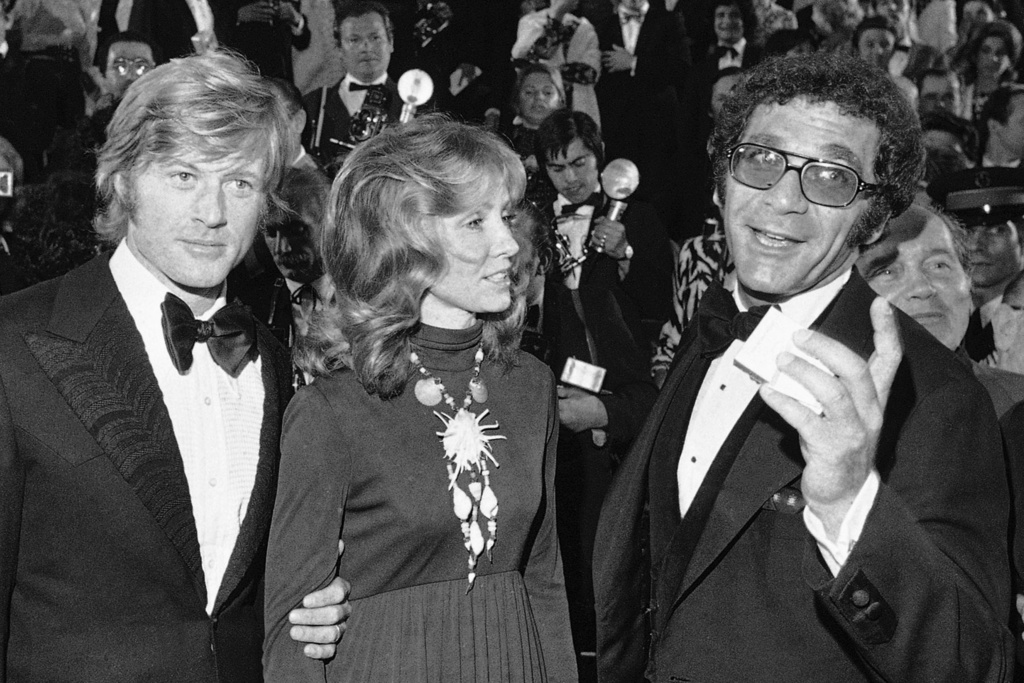 FILE - Robert Redford, from left, his wife Lola, and director Sydney Pollack appear at the presentation of the film "Jeremiah Johnson" during the Cannes Film Festival in Cannes, France on May 7, 1972. (AP Photo/Jean-Jacques Levy, File)