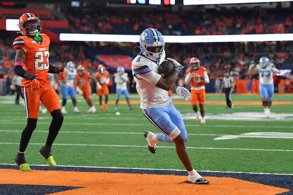 North Carolina wide receiver Jordan Shipp, right, scores a touchdown in front of Syracuse defensive back Devin Grant, left, during the second half of an NCAA college football game Friday, Oct. 31, 2025, in Syracuse, N.Y. (AP Photo/Adrian Kraus)