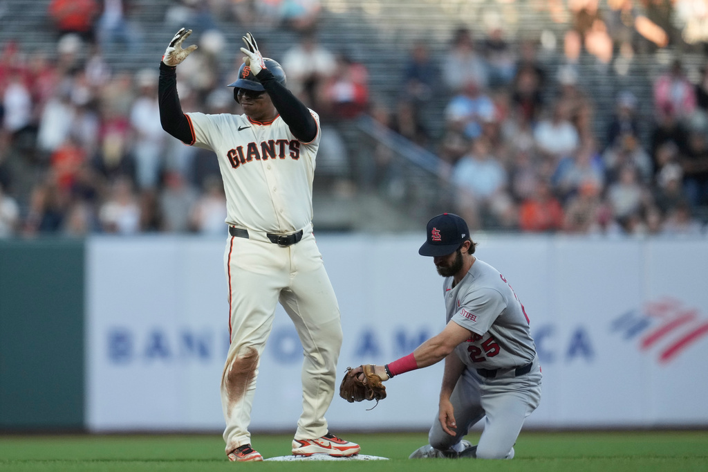 San Francisco Giants' Rafael Devers, left, gestures after hitting a double next to St. Louis Cardinals shortstop Thomas Saggese during the fifth inning of a baseball game, Monday, Sept. 7, 2026, in San Francisco. (AP Photo/Jeff Chiu)
