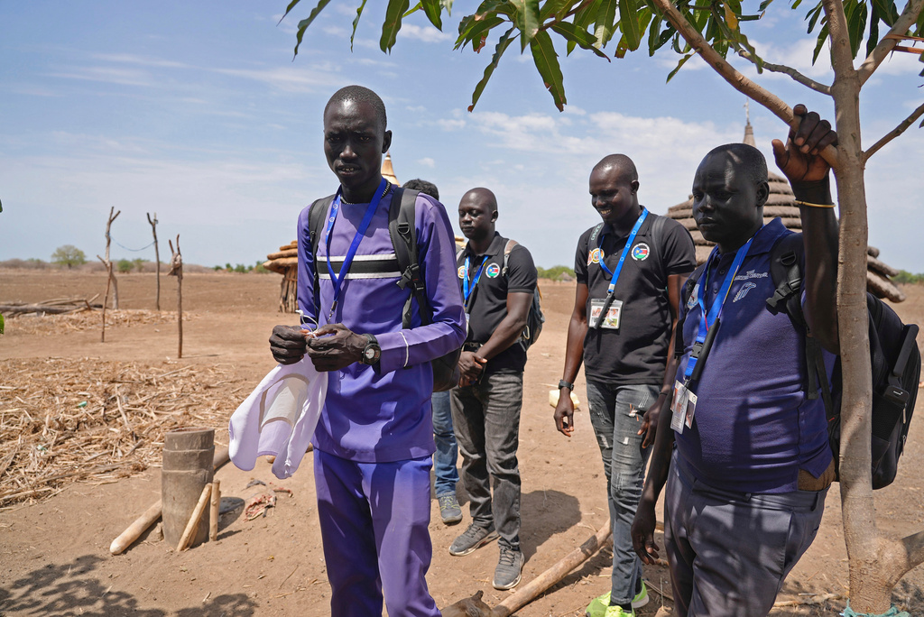 FILE - Aid workers with the Carter Center work in the community to raise awareness about Guinea worm and a family impacted in Jarweng, South Sudan, on May 13, 2023. (AP Photo/Sam Mednick, file)