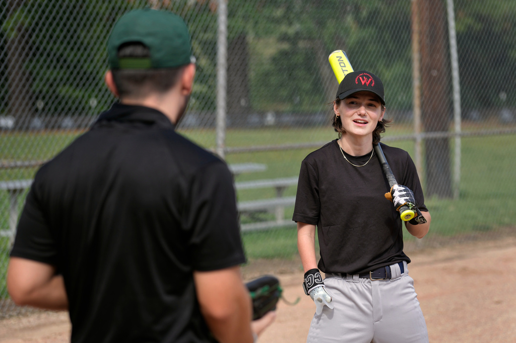 Brittany Apgar, right, who was born without a right hand, talks with Logan Vacharasin, left, before batting practice at a field in Greensboro, N.C., Wednesday, July 22, 2026 before joining the Los Angeles team in the Women's Pro Baseball League. (AP Photo/Chuck Burton)