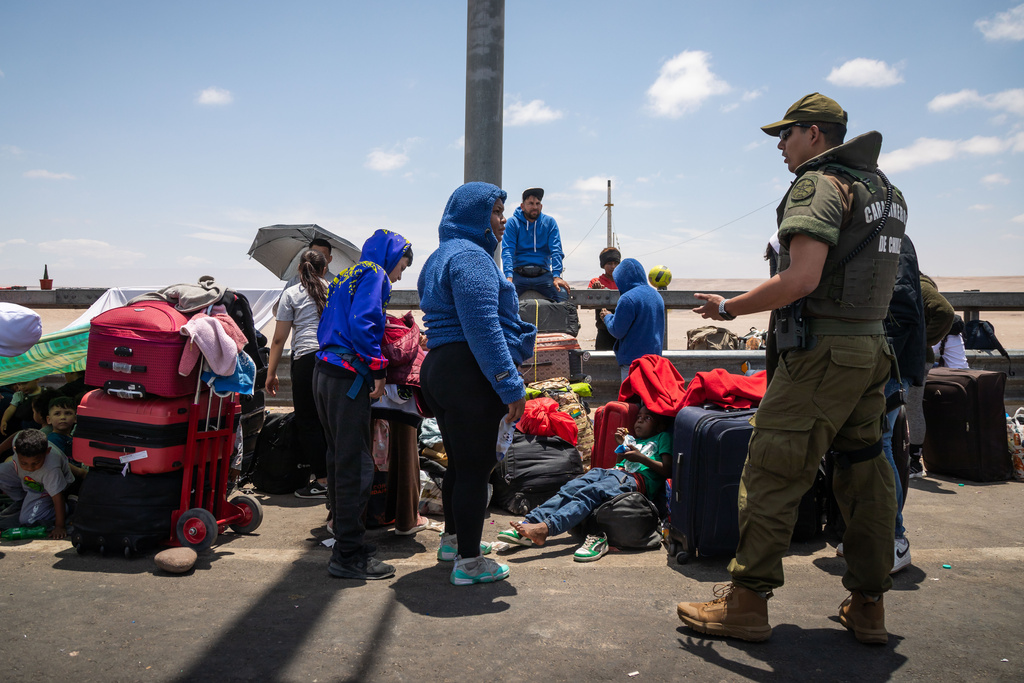Migrants, mostly from Venezuela, wait to cross into Peru at the Chacalluta border crossing point in Arica, Chile, Friday, Nov. 28, 2025. (AP Photo/Ibar Silva)