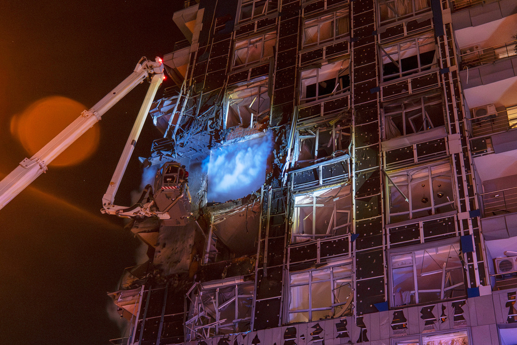 Emergency services personnel work to extinguish a fire following a Russian attack in Kyiv, Ukraine, Tuesday, Nov. 25, 2025. (AP Photo/Dan Bashakov)