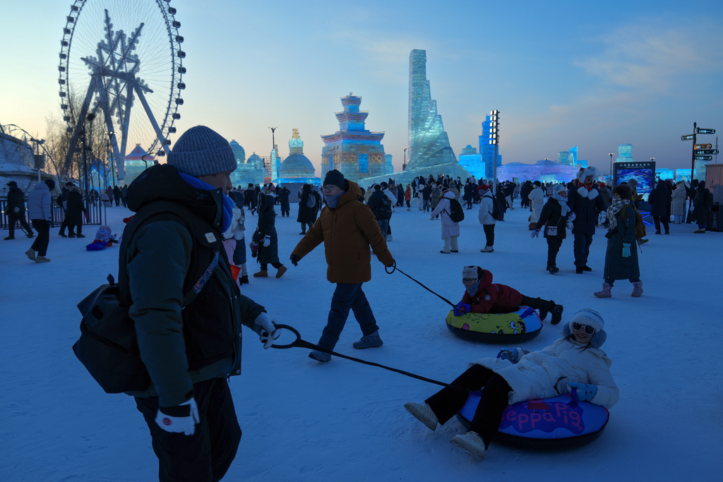 Visitors tour the illuminated ice structures at the Harbin Ice and Snow World in Harbin, China's Heilongjiang province on Monday, Jan. 6, 2025. (AP Photo/Andy Wong)