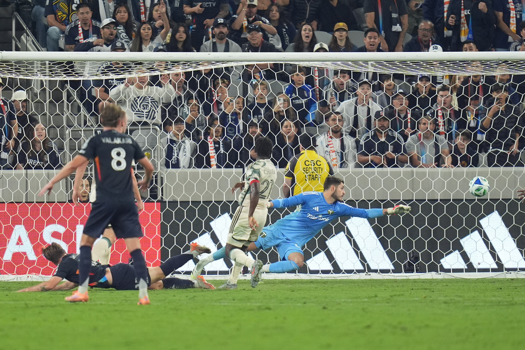 San Diego FC midfielder Anders Dreyer, left, watches his header get past Portland Timbers goalkeeper James Pantemis and go in for a goal during the first half of Game 1 in the first round of MLS soccer's Western Conference playoff Sunday, Oct. 26, 2025, in San Diego. (AP Photo/Gregory Bull)