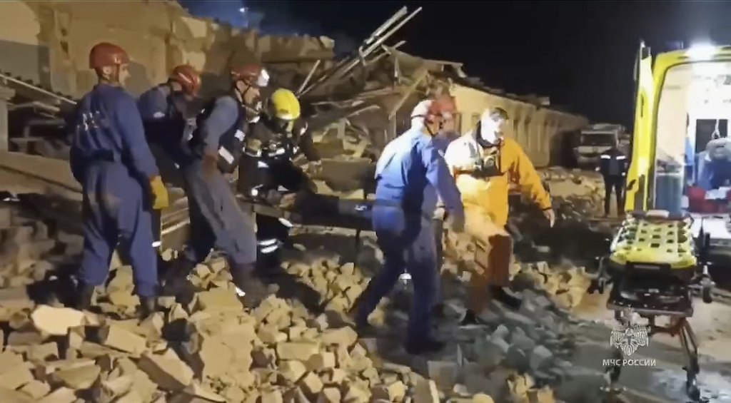 In this photo, released by the Russian Emergency Ministry Press Service on Saturday, Aug. 16, 2025, Emergency Ministry employees carry a wounded person through debris of an industrial plant after a fire at the facility in the Shilovsky District, Ryazan region, around 250 kilometers (155 miles) southeast of Moscow, Russia. (Russian Emergency Ministry Press Service via AP)