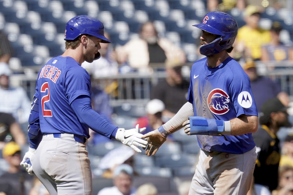 Chicago Cubs' Dansby Swanson, right, is greeted by Nico Hoerner, left, after scoring during the sixth inning of a baseball game against the Pittsburgh Pirates, Wednesday, Sept. 17, 2025, in Pittsburgh. (AP Photo/Matt Freed)