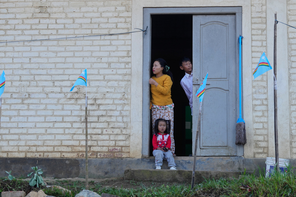 People look out from their door waiting for the arrival of Thuingaleng Muivah, leader of the National Socialist Council of Nagaland (Isak-Muivah), in Ukhrul, in the northeastern Indian state of Manipur, Wednesday, Oct. 22, 2025. (AP Photo/Anupam Nath)