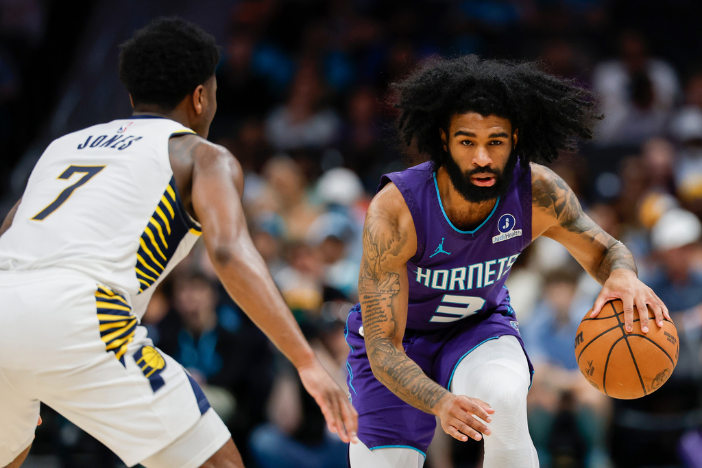 Charlotte Hornets guard Coby White (3) moves the ball against Indiana Pacers guard Kam Jones (7) during the first half of an NBA basketball game in Charlotte, N.C., Friday, April 3, 2026. (AP Photo/Nell Redmond)
