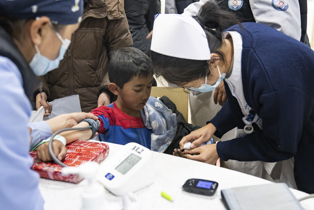 In this photo released by Xinhua News Agency, medical workers attend to an injured child in the aftermath of an earthquake at the Xigaze People's Hospital in Xigaze City, southwest China's Tibet Autonomous Region, Wednesday Jan. 8, 2025. (Tenzin Nyida/Xinhua via AP)