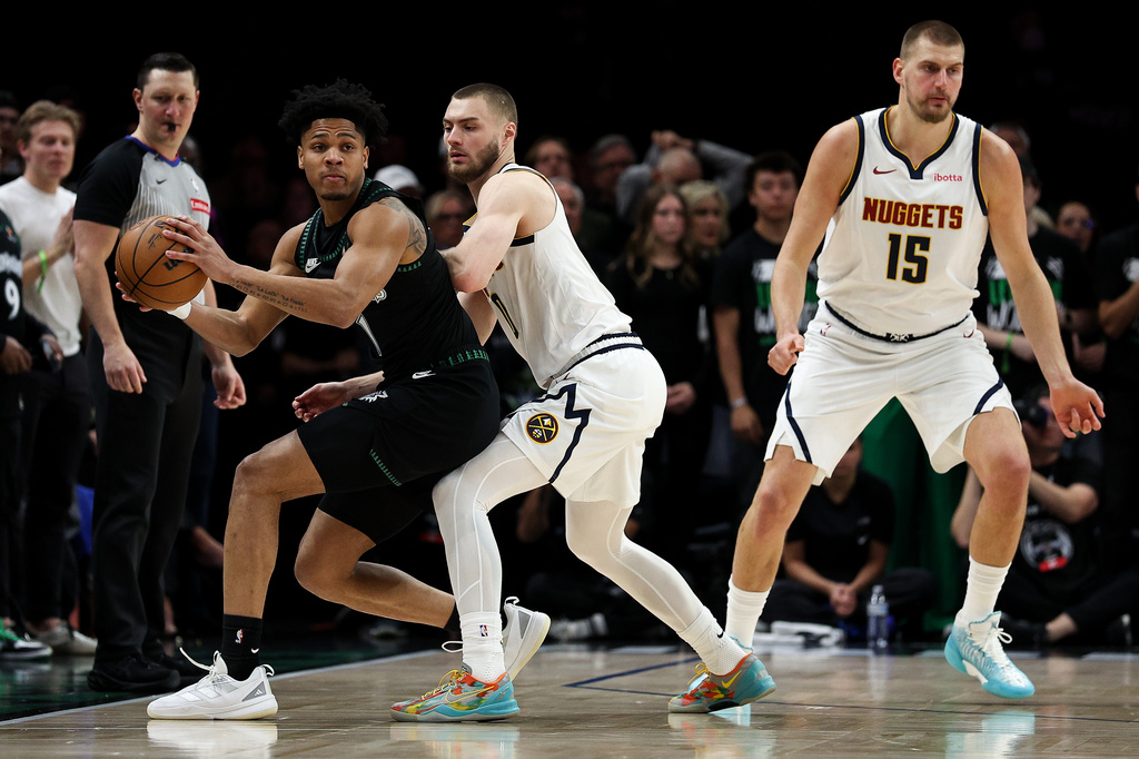 Minnesota Timberwolves guard Terrence Shannon Jr., left, controls the ball as Denver Nuggets guard Christian Braun, center, defends during the first half of Game 6 of a first-round NBA basketball playoffs series, Thursday, April 30, 2026, in Minneapolis. (AP Photo/Matt Krohn)