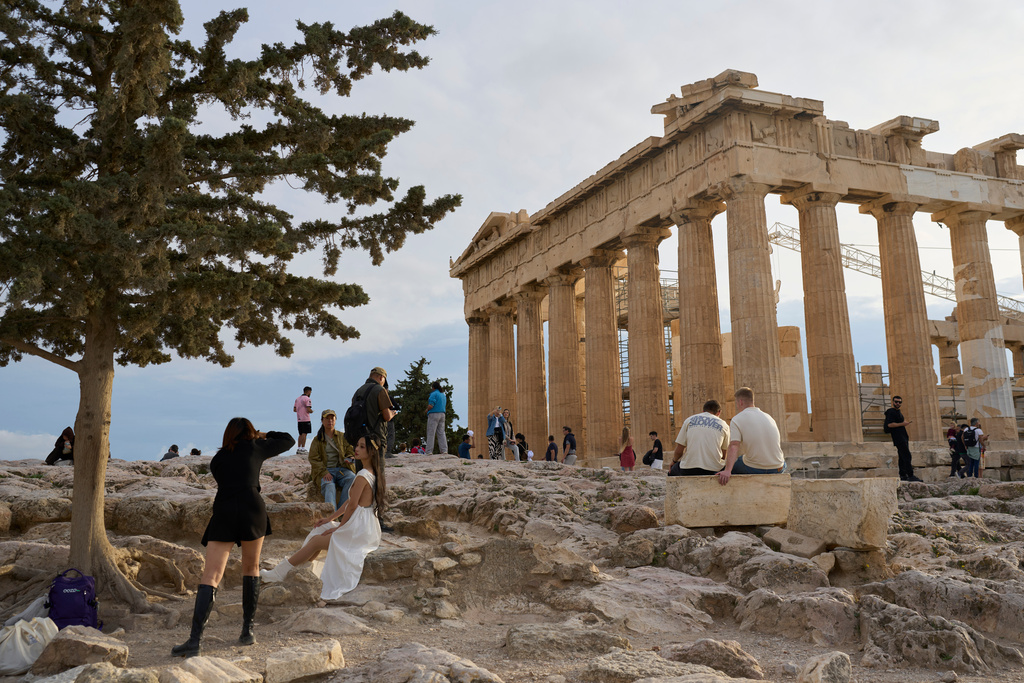 Tourists visit the 5th century B.C. Parthenon temple atop the Acropolis hill in Athens, Friday, Oct. 31, 2025. (AP Photo/Petros Giannakouris)
