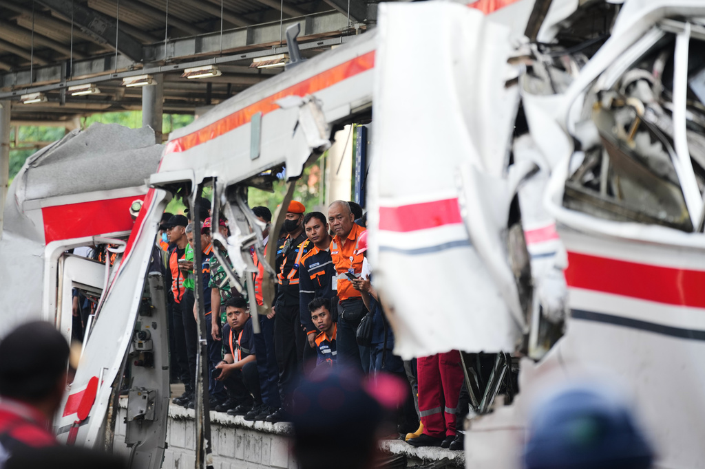 Workers and rescuers examine the wreckage following a train collision in Bekasi, Indonesia, Tuesday, April 28, 2026. (AP Photo/Tatan Syuflana)