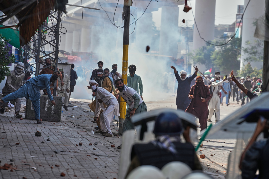 Supporters of Islamist party 'Tehreek-e-Labbaik Pakistan' throw stones toward police during clashes ahead of their pro-Palestinian march toward capital Islamabad, in Lahore, Pakistan, Friday, Oct. 10, 2025. (AP Photo/K.M. Chaudary)