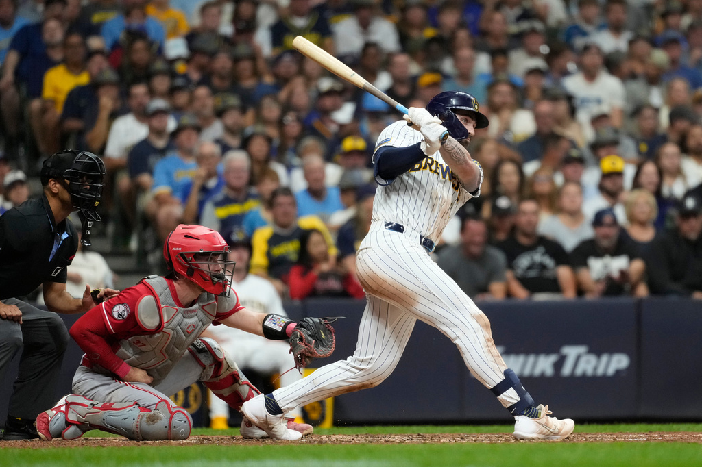 Milwaukee Brewers' Garrett Mitchell, right, watches his two-run double during the fifth inning of a baseball game against the Cincinnati Reds, Saturday, Sept. 12, 2026, in Milwaukee. (AP Photo/Aaron Gash)