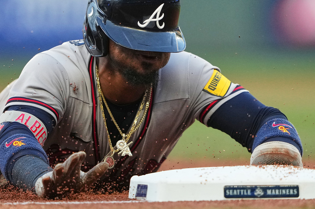 Atlanta Braves' Ozzie Albies slides into third base on a single from Matt Olson during the fourth inning of a baseball game against the Seattle Mariners, Tuesday, May 5, 2026, in Seattle. (AP Photo/Lindsey Wasson)