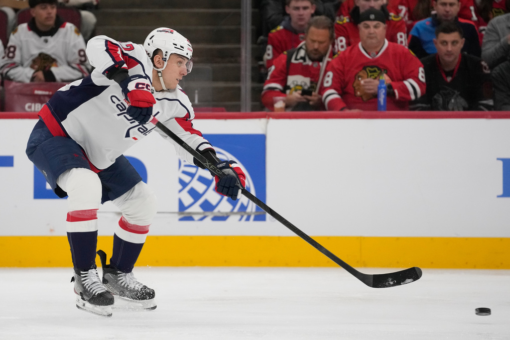 Washington Capitals defenseman Martin Fehérváry (42) shoots the puck as he assists left wing Anthony Beauvillier (72) in scoring a goal on the Chicago Blackhawks during the first period of an NHL hockey game Friday, Jan. 9, 2026, in Chicago. (AP Photo/Erin Hooley)