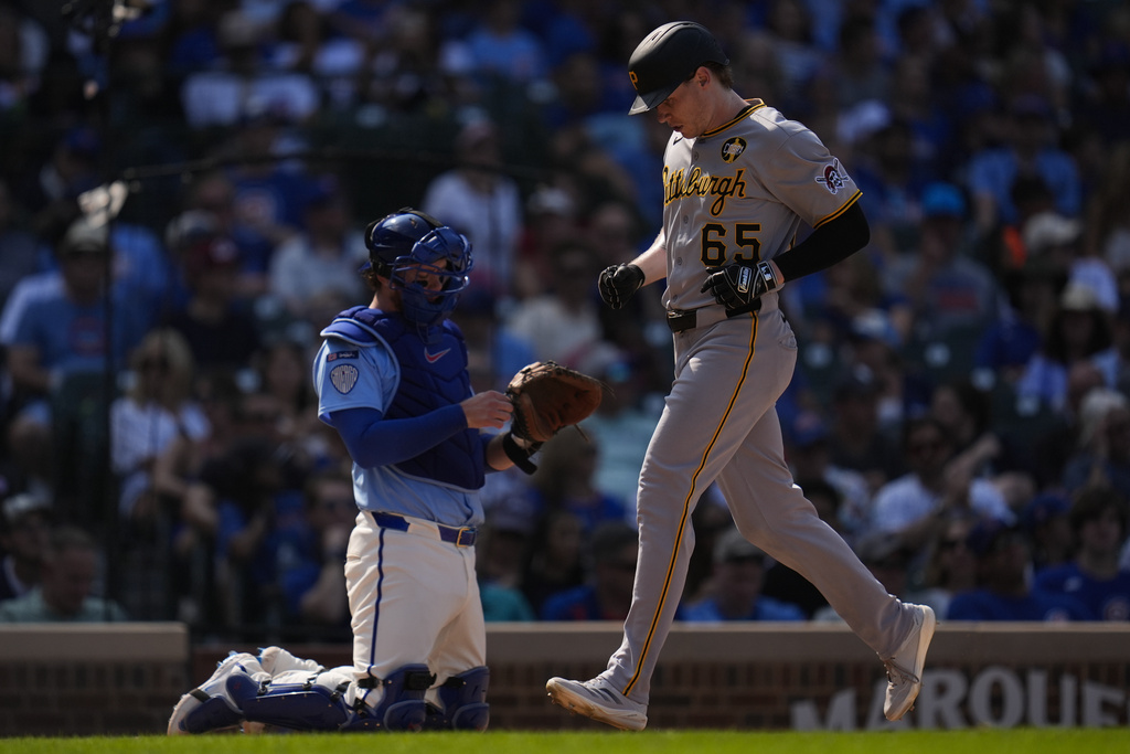 Pittsburgh Pirates' Jack Suwinski, right, crosses home plate to score pas Chicago Cubs catcher Carson Kelly after hitting a home run during the ninth inning of a baseball game Friday, Aug. 15, 2025, in Chicago. (AP Photo/Erin Hooley)