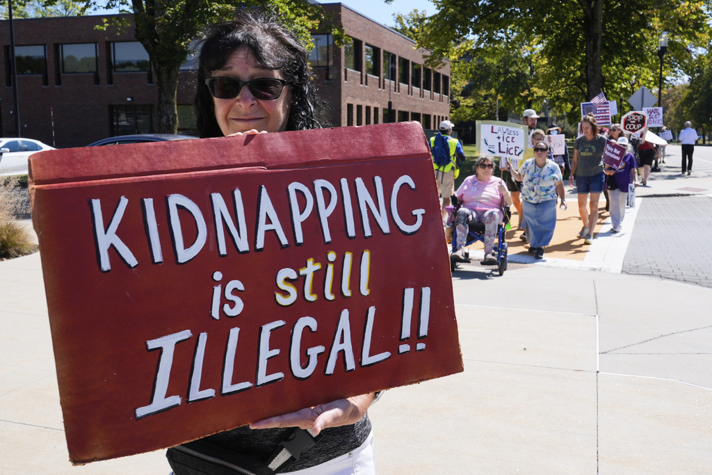 Protesters picket near the U.S. Immigration and Customs Enforcement regional field office, Thursday, Sept. 11, 2025, in Burlington, Mass. (AP Photo/Charles Krupa)