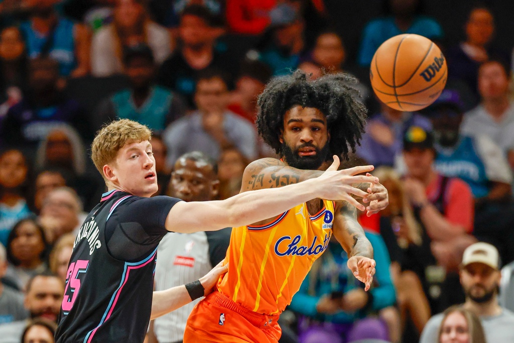 Charlotte Hornets guard Coby White, right, passes against Miami Heat guard Kasparas Jakucionis during the first half of an NBA basketball game in Charlotte, N.C., Friday, March 6, 2026. (AP Photo/Nell Redmond)
