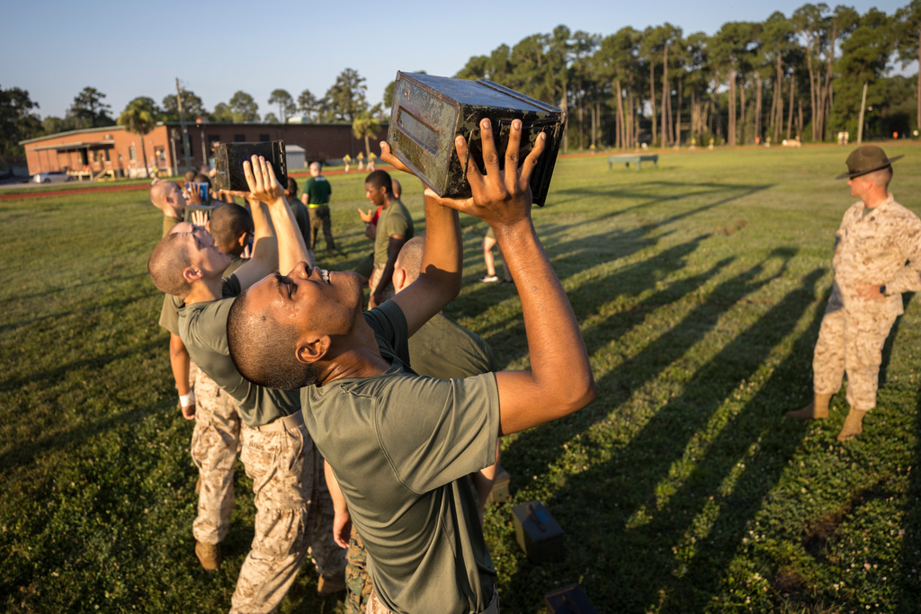 FILE - A group of male U.S. Marine Corps recruits train with weighted ammo cans during a physical training exercise at the Marine Corps Recruit Depot, June 28, 2023, in Parris Island, S.C. (AP Photo/Stephen B. Morton, File)