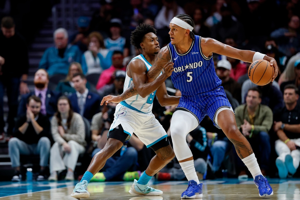 Orlando Magic forward Paolo Banchero (5) drives into Charlotte Hornets guard Collin Sexton, left, during the first half of an NBA basketball game in Charlotte, N.C., Thursday, Oct. 30, 2025. (AP Photo/Nell Redmond)