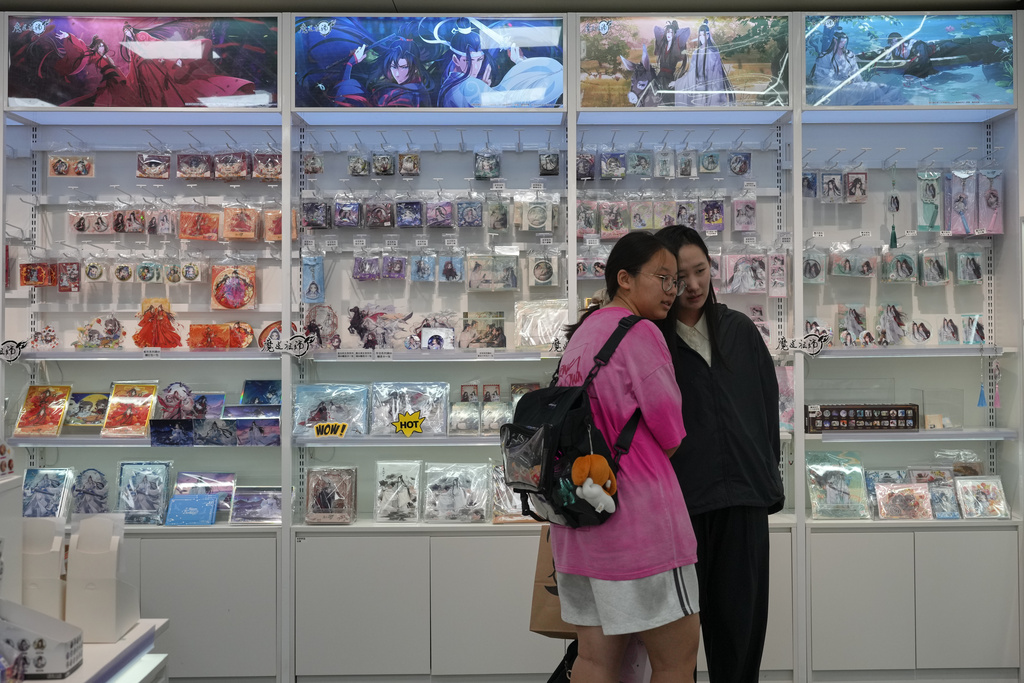 Women chat near the shelf displaying the Boys' Love stories merchandize items for sale at a comic store, in Beijing on July 14, 2025. (AP Photo/Andy Wong)