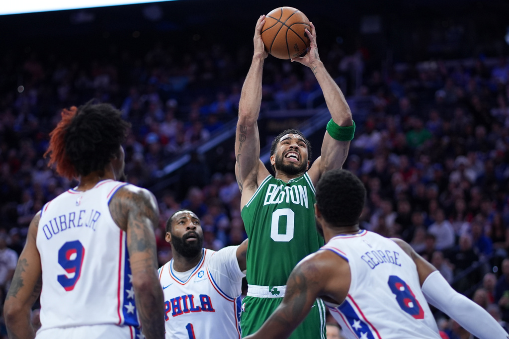 Boston Celtics' Jayson Tatum (0) goes up for a shot against Philadelphia 76ers' Paul George (8), Andre Drummond (1) and Kelly Oubre Jr. (9) during the first half of Game 6 in a first-round NBA basketball playoff series Thursday, April 30, 2026, in Philadelphia. (AP Photo/Matt Slocum)