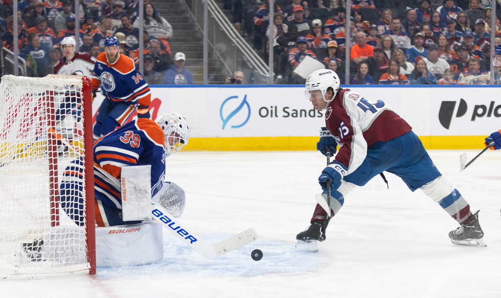 Colorado Avalanche's Jack Ahcan (15) is stopped by Edmonton Oilers goalie Connor Ingram (39) during third period NHL action, in Edmonton on Monday, April 13, 2026. (Jason Franson/The Canadian Press via AP)