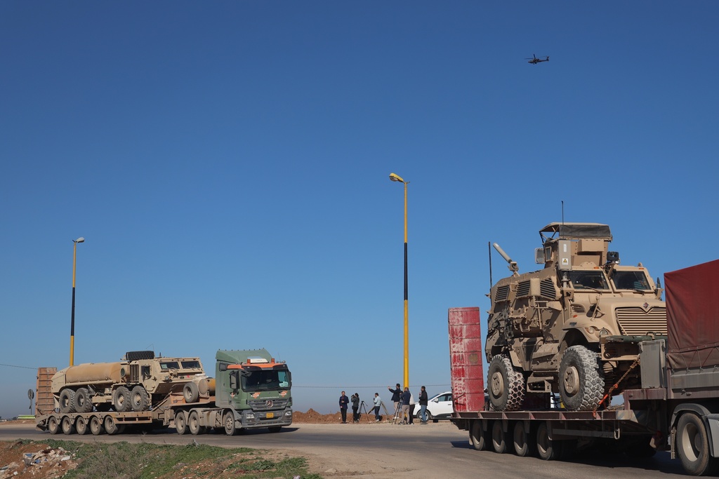 A convoy carrying U.S. Army vehicles drives away from the International Coalition's Qasrak Base, its largest base in northeastern Syria, heading toward Iraqi territory on the outskirts of Qamishli, eastern Syria, Monday, Feb. 23, 2026.(AP Photo/Baderkhan Ahmad)