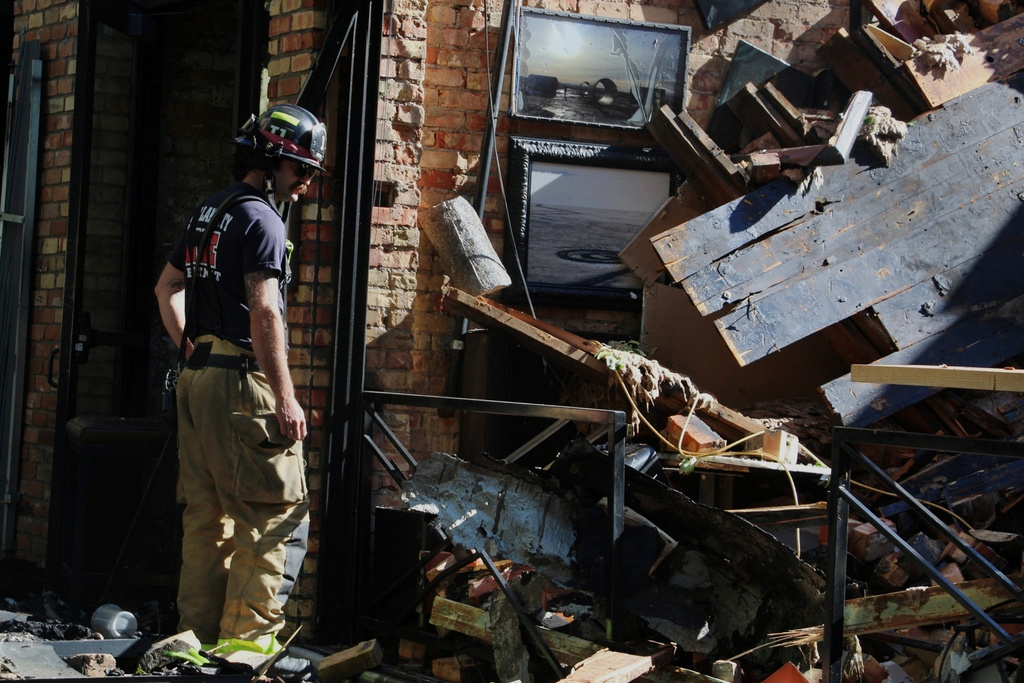 A firefighter surveys the damage of a blaze in downtown Salt Lake City that injured three firefighters and burned several bars and restaurants, Tuesday, Aug. 12, 2025. (AP Photo/Hannah Schoenbaum)