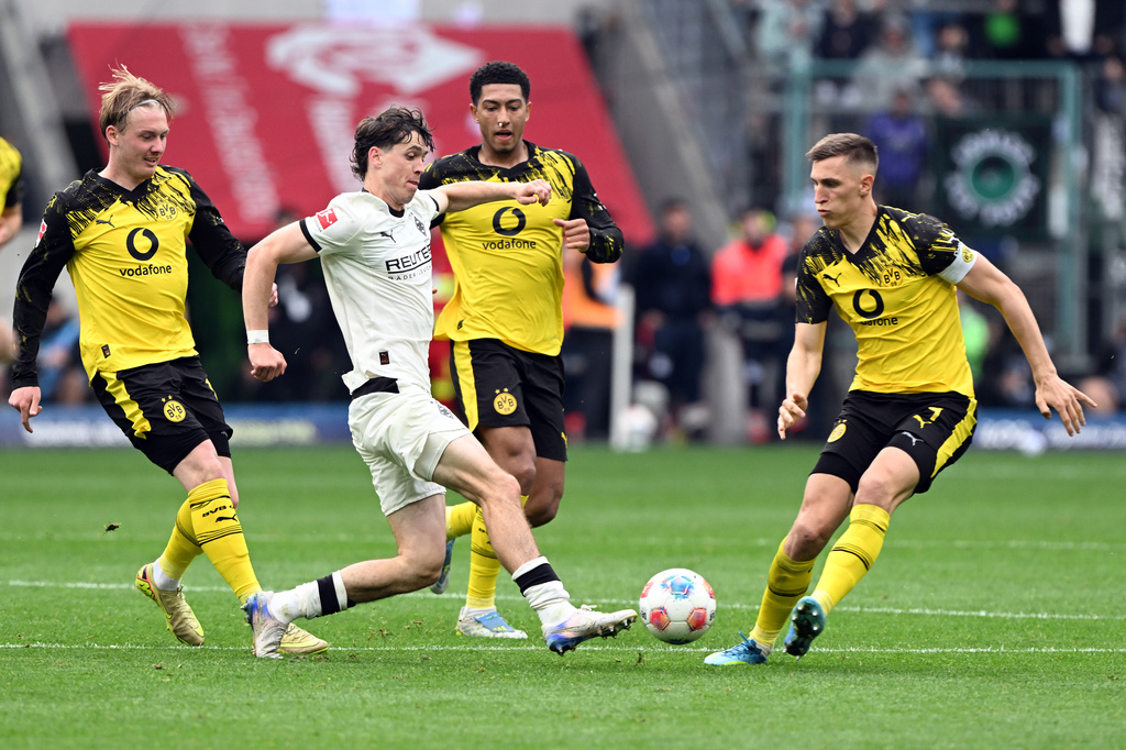 Mönchengladbach's Philipp Sander, second from left, challenges for the ball with Dortmund's Julian Brandt, left, Jobe Bellingham, second from right, and Nico Schlotterbeck during the German Bundesliga soccer match between Borussia Mönchengladbach and Borussia Dortmund in Mönchengladbach, Germany, Sunday, May 3, 2026. (Federico Gambarini/dpa via AP)