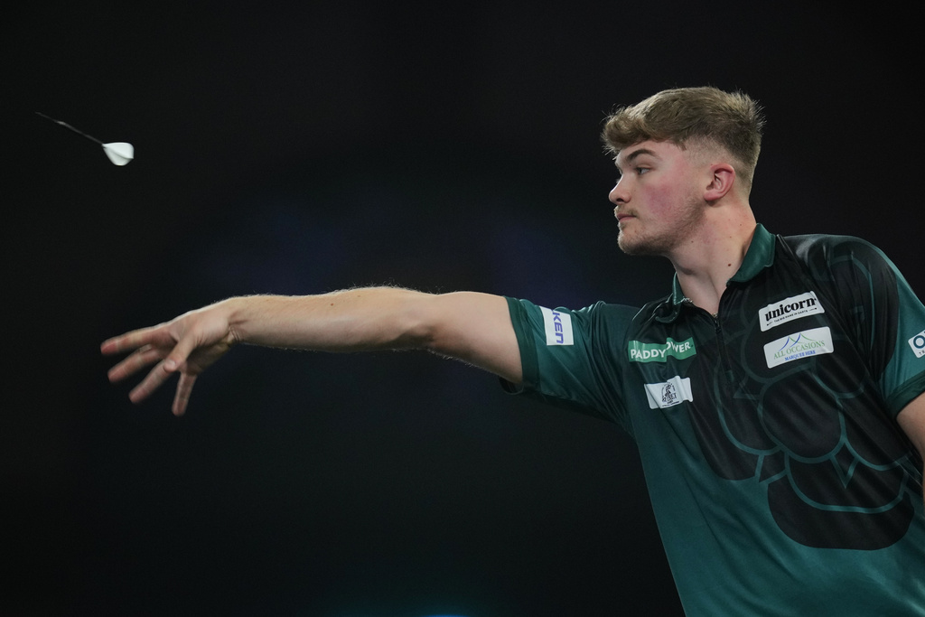 Charlie Manby of England throws a dart as he takes part in a round one match at the World Darts Championships, at Alexandra Palace in London, Monday, Dec. 15, 2025. (AP Photo/Kin Cheung)