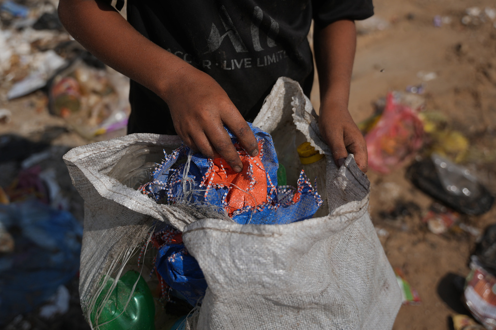 Palestinians search through a garbage dump for combustible materials to use as fuel for cooking due to a shortage of cooking gas, in Deir al-Balah, central Gaza Strip, Saturday, Aug. 22, 2026. (AP Photo/Abdel Kareem Hana)