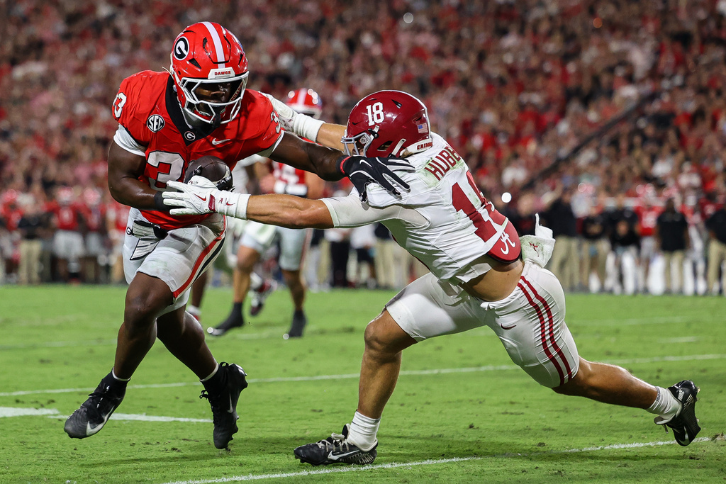 Georgia running back Chauncey Bowens, left, runs with the ball against Alabama defensive back Bray Hubbard, right, during the first half of an NCAA college football game, Saturday, Sept. 27, 2025, in Athens, Ga. (AP Photo/Colin Hubbard)